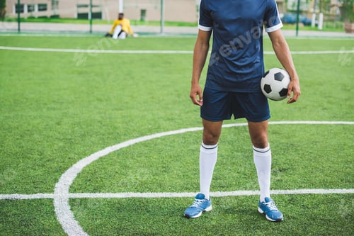 Vista previa: partial view of soccer player holding ball while standing on soccer pitch