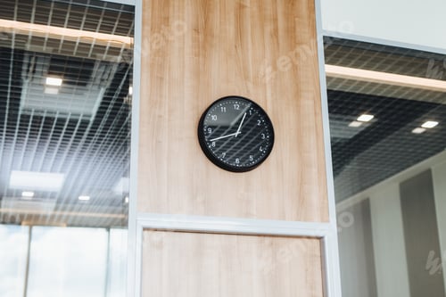 Preview: Round clock against office interior, symbolizes dinner break, no one at work