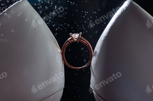 Preview: Gold ring of the bride with a pebble between white shoes with heels. Bride's precious ring