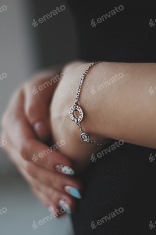Visualização: Vertical shot of a young female wearing a beautiful silver bracelet