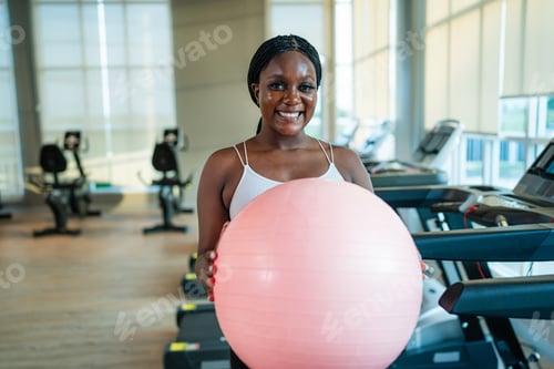 Visualização: Garota fitness levantando pesos e se exercitando em várias estações na academia para músculos dos braços e ombros.