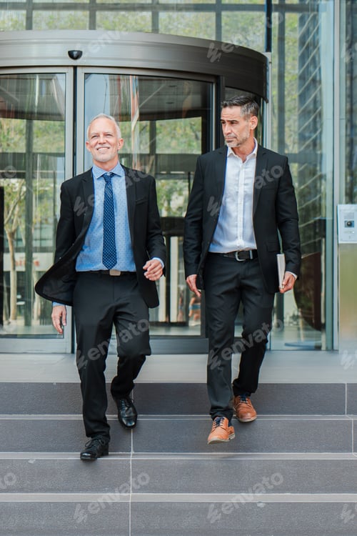 Preview: Vertical. Confident business men walking down the staircase, talking about the corporate finance