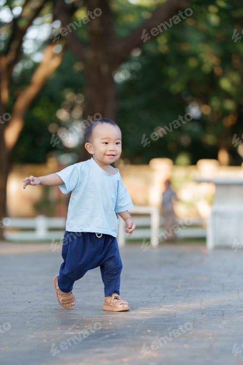 Preview: Happy young asian baby walking outdoors in park