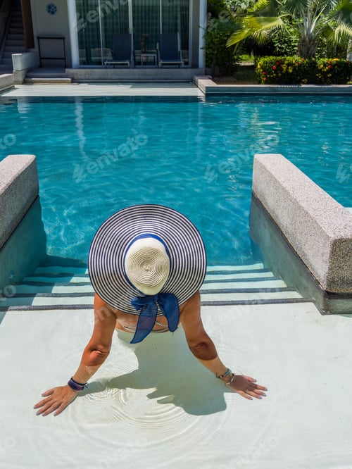 Preview: woman in luxury spa resort near the swimming pool.