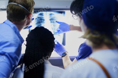 Preview: Shot of a team of surgeons discussing a patients x rays during surgery