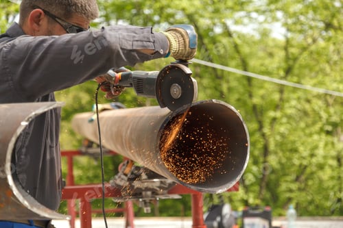 Preview: Worker cuts metal product with electric flex