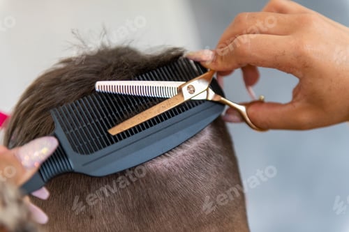 Preview: Stylist giving a precise haircut with focus on the details.
