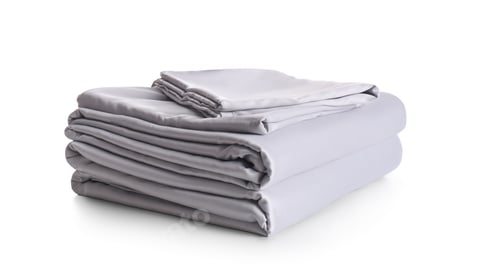Preview: Stack of clean silky bed linen isolated on white