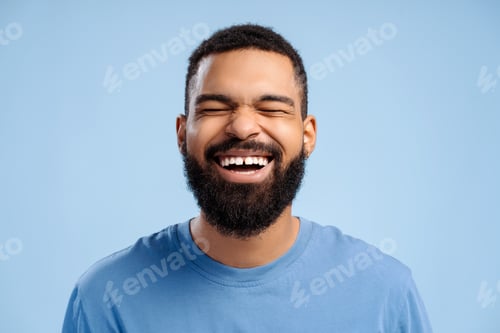 Preview: Attractive, emotional African American bearded man with teeth smile with closed eyes