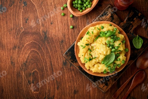 Preview: Mashed potato with butter, green peas, onions, basil on a rustic wooden background. Top view with cl