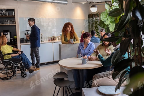 Preview: Diverse colleagues communicating during an office break in a modern kitchen