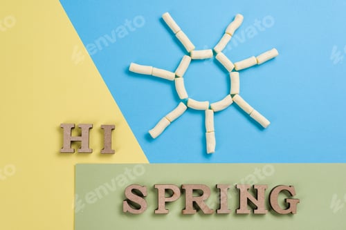 Preview: Hi spring, abstract image with wooden letters on the background of the sun and blue yellow green