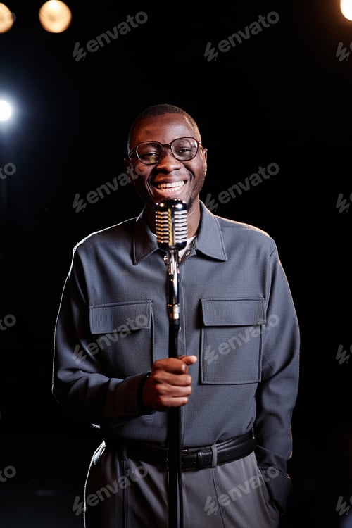 Preview: Man Speaking to Microphone on Stage