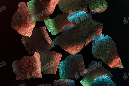 Preview: abstract background of silver textured foil pieces with colorful illumination isolated on black