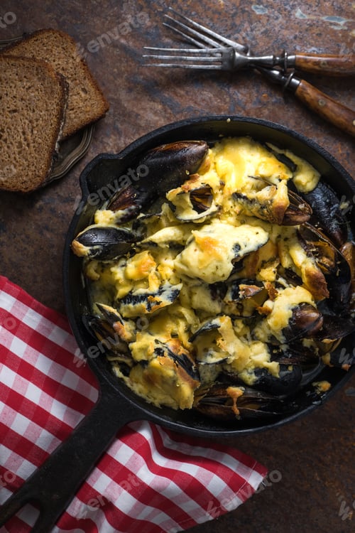 Preview: Mussels with cheese sauce in a frying pan, napkin in a red cage