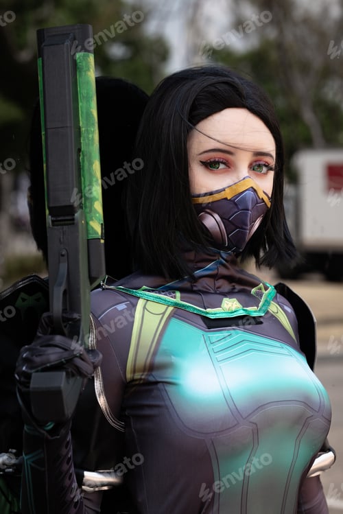 Preview: Female cosplayer in a green action suit against a mirrored window