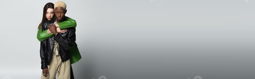 Preview: young brunette woman embracing blonde african american man while looking at camera on grey, banner