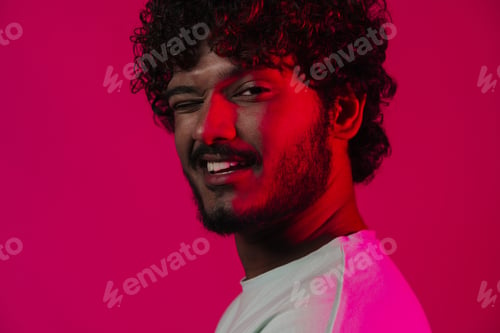 Preview: Young middle eastern man smiling and winking at camera