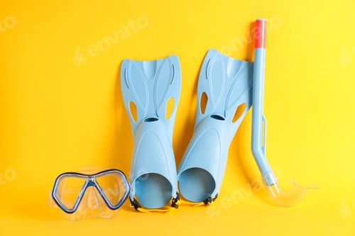 Preview: Flippers, snorkel and diving mask on yellow background, space for text