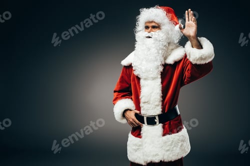 Preview: happy santa claus in costume waving by hand isolated on grey background