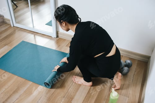Preview: Woman Rolling Up Yoga Mat