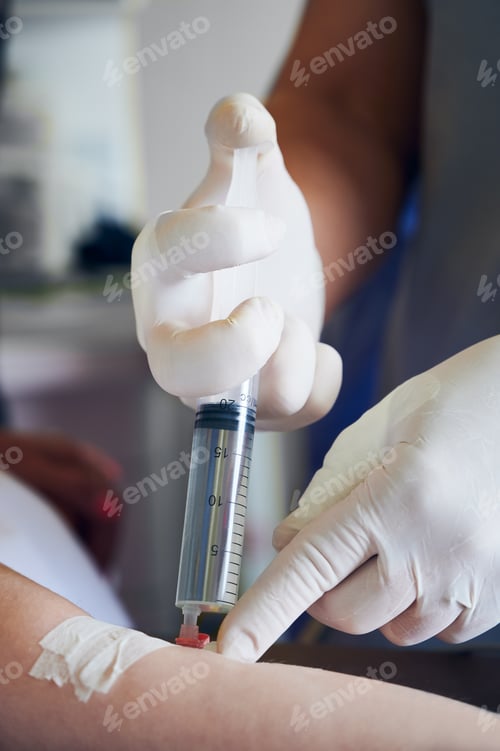 Preview: Doctor hands injecting anesthetic medicine into patient arm.