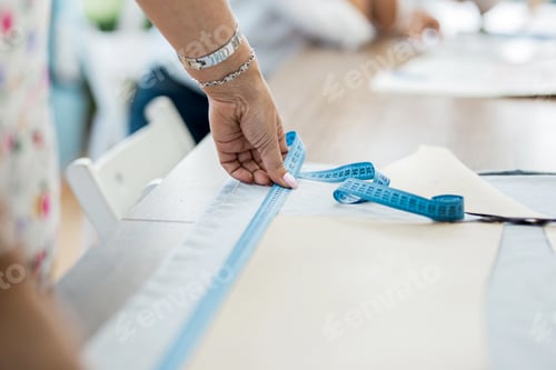 Preview: A woman with a bracelet is measuring fabric. Fashion, tailor's workshop