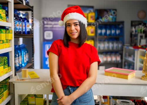 Preview: Young woman smiling, wearing a santa hat and red shirt in an auto parts store