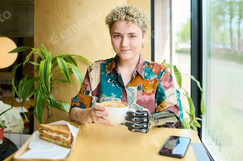 Preview: Happy young female with disability looking at camera while resting in cafe