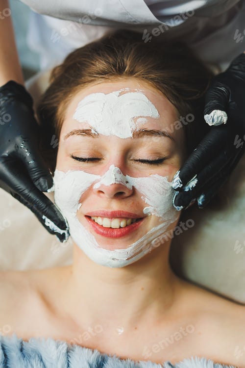 Preview: The hands of a beautician apply a mask to a woman's face in a spa salon. Aesthetic procedure