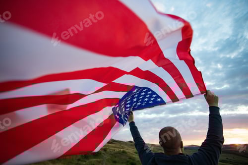 Preview: Man holding a waving american USA flag.