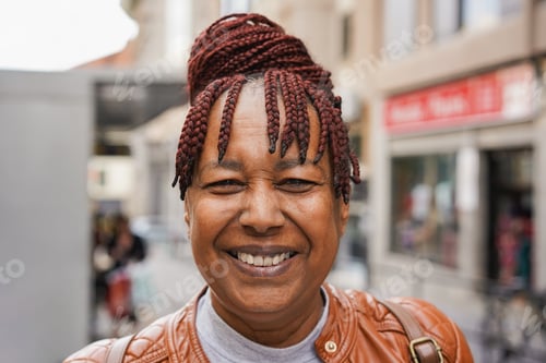Preview: Happy senior african woman smiling on camera in the city
