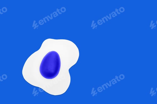 Preview: Creative layout made of scrambled eggs with painted blue half Easter eggs on a blue background.