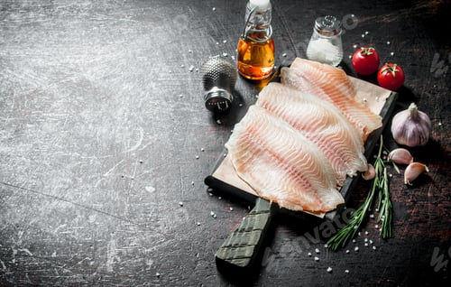 Preview: Fish fillet on a cutting Board with spices, rosemary, garlic and oil.