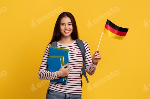 Preview: Happy young asian woman student showing flag of Germany