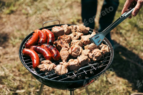 Preview: Meat is fried on a campfire, barbecue in nature. Pickled meat is cooked on coals, Grilled BBQ.