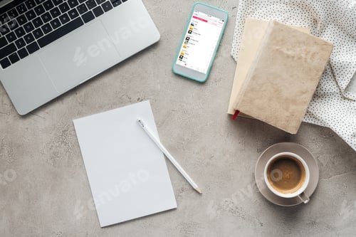 Preview: top view of coffee with laptop and smartphone with music player app on screen on concrete surface