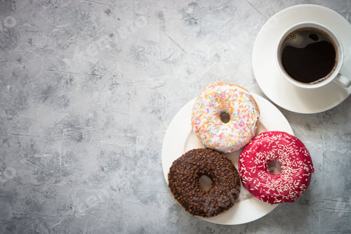 Preview: Colorful donuts at concrete table.