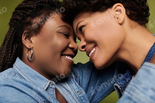 Preview: Loving moment shared between stylish lesbian couple in vibrant fashion on a bright background