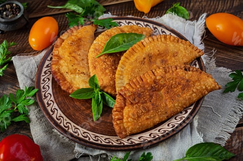 Preview: Traditional Crimean Tatar cuisine, chebureki with chicken meat. Fried empanadas on wooden background