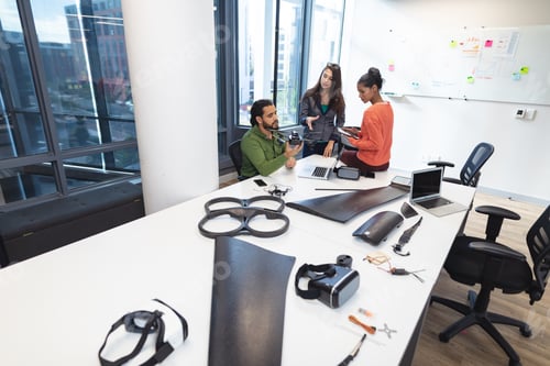 Preview: Diverse group of creative colleagues talking at meeting