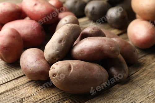 Preview: Different types of potatoes on wooden table, closeup