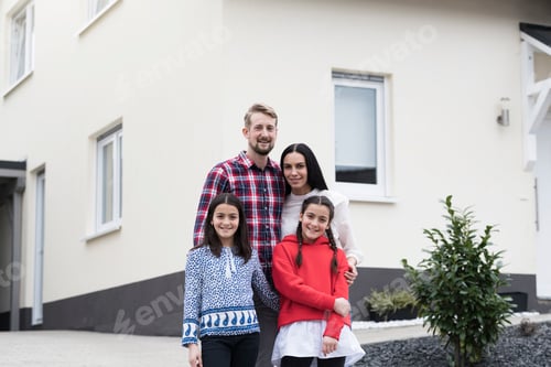 Preview: Portrait of parents and twin daughters in front of their family home