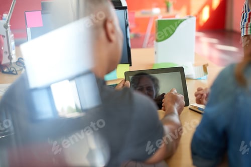 Preview: Unposed group of creative business people in an open concept office brainstorming.