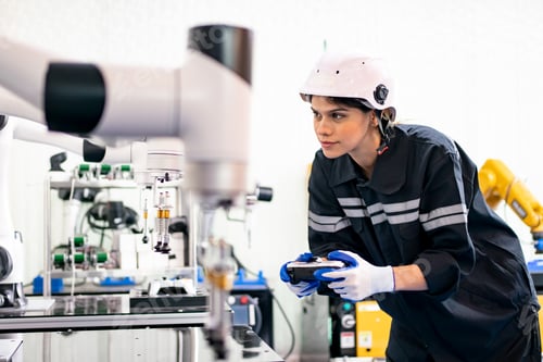 Preview: Female Engineer check and control automation robot arms machine in factory. robotics manufacturing.