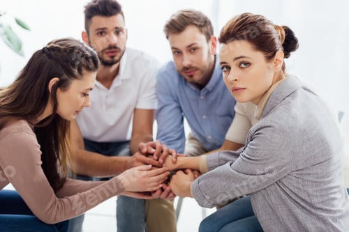 Preview: group of people sitting and stacking hands during therapy session