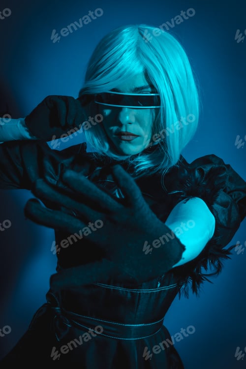 Preview: Portrait of cosplay woman in black costume and a white wig in studio with blue led light
