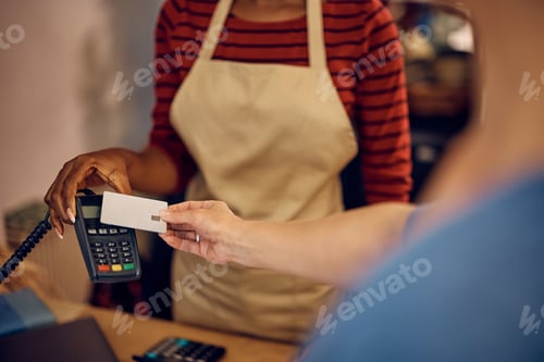 Preview: Close up of flower shop customer paying contactless with credit card.