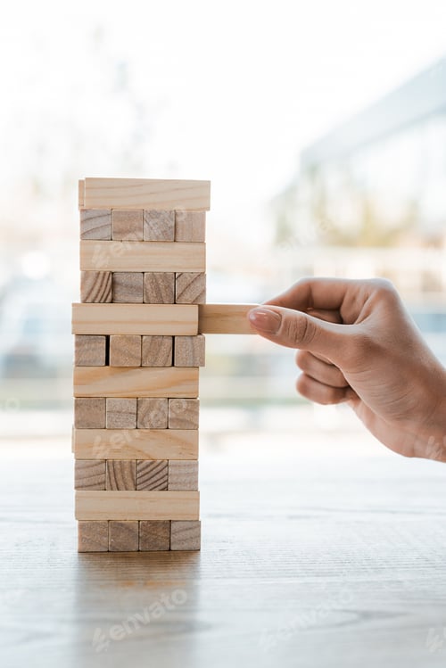 Preview: KYIV, UKRAINE - NOVEMBER 22, 2019: cropped view of woman taking block while playing wood tower game