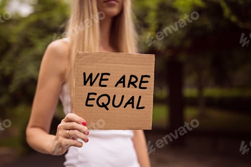 Preview: Woman holding hands gender equality sign with inscription “we are equal”